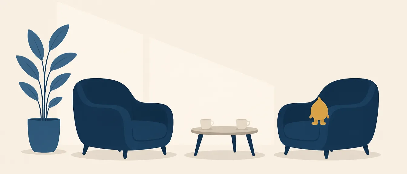 Dos butacas azules enfrentadas con una mesa baja en medio y dos tazas servidas, en una sala luminosa y tranquila